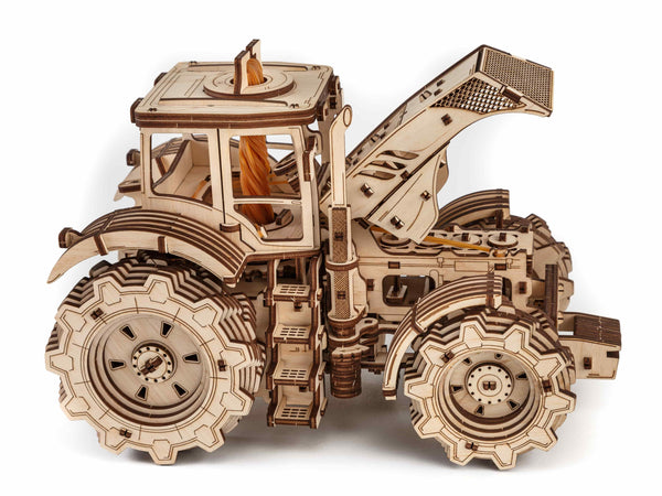 Igrača lesena 3D sestavljanka belo ozadje tractor igrača odprt pokrov motorja od strani